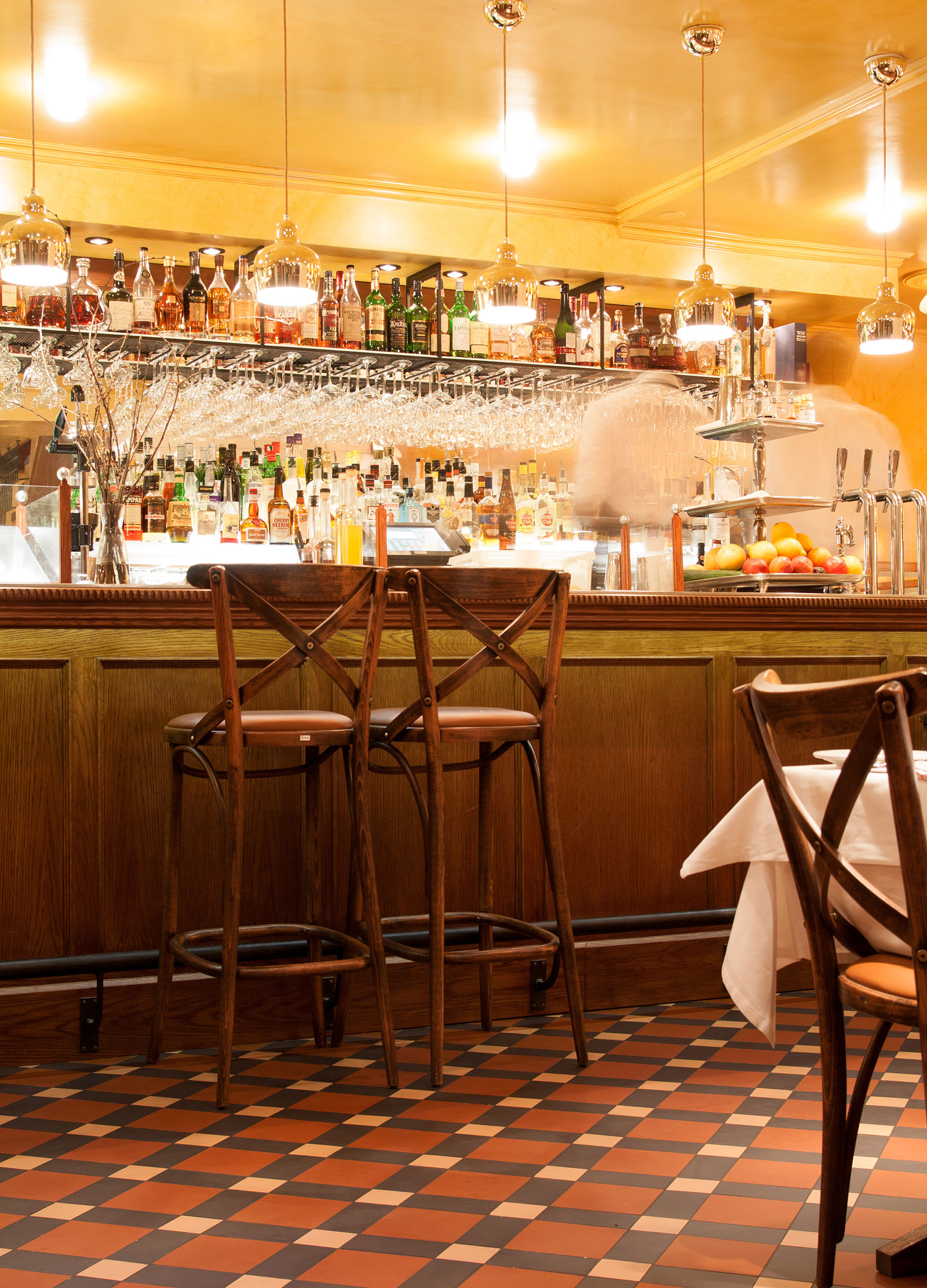 Bardisk med barstolar i tr&auml; p&aring; m&ouml;nstrat klinkergolv.