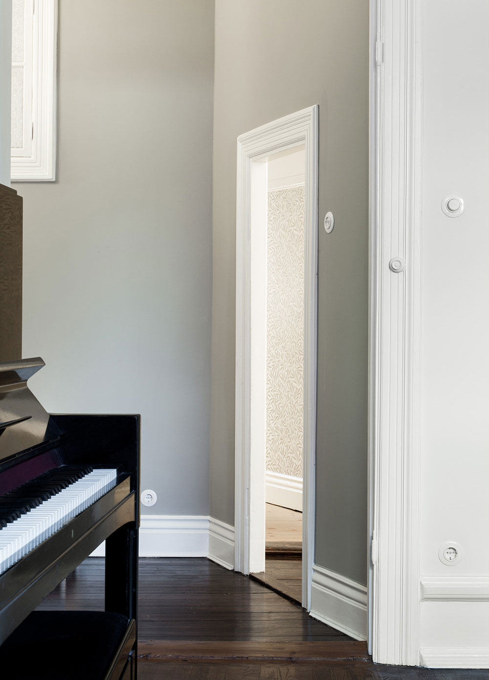 Vardagsrum med bevarade originalsnickerier i sekelskiftesl&auml;genhet.