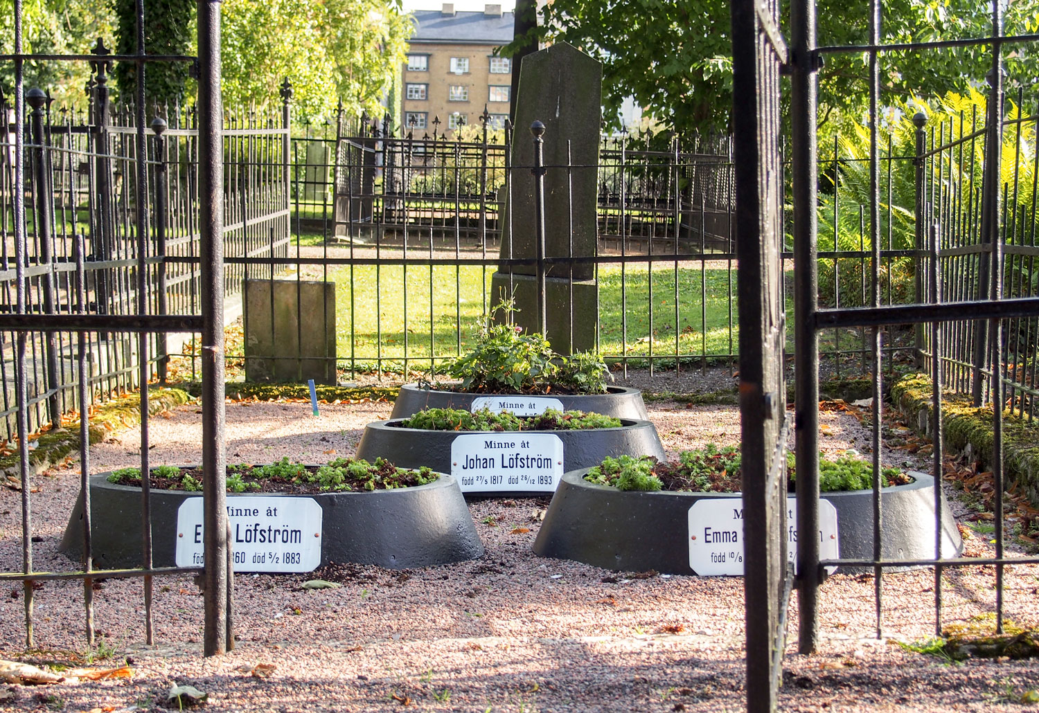 Gravplatser med vita emaljskyltar med svarta bokst&auml;ver.