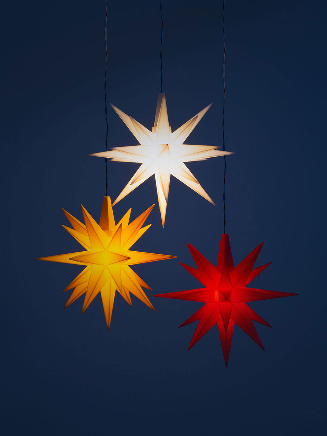 Tre sm&aring; herrnhutstj&auml;rnor i vit, gul respektive r&ouml;d.