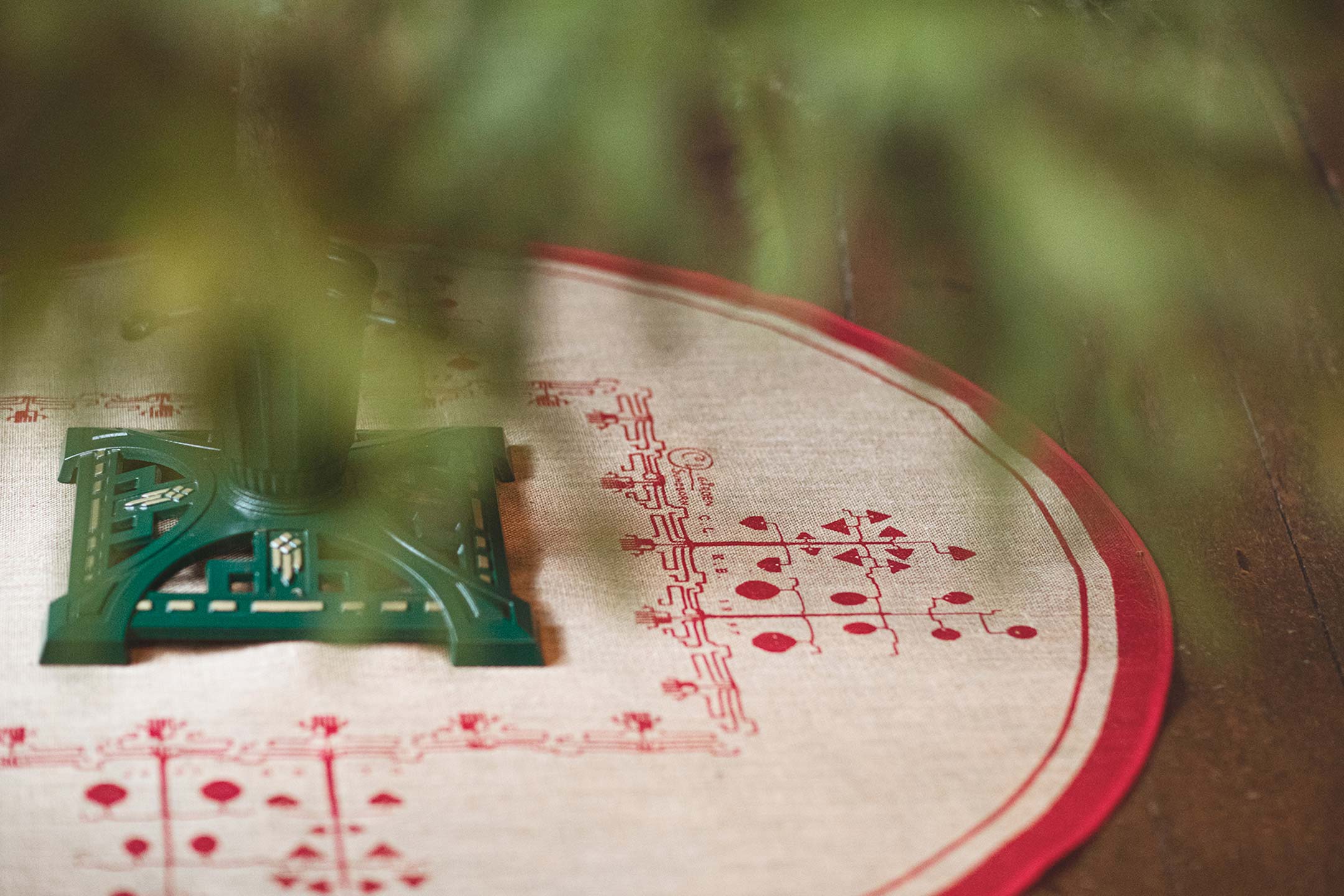 Gr&ouml;n julgransfot i gjutj&auml;rn p&aring; julgransmatta. B&aring;da fr&aring;n Byggfabriken.