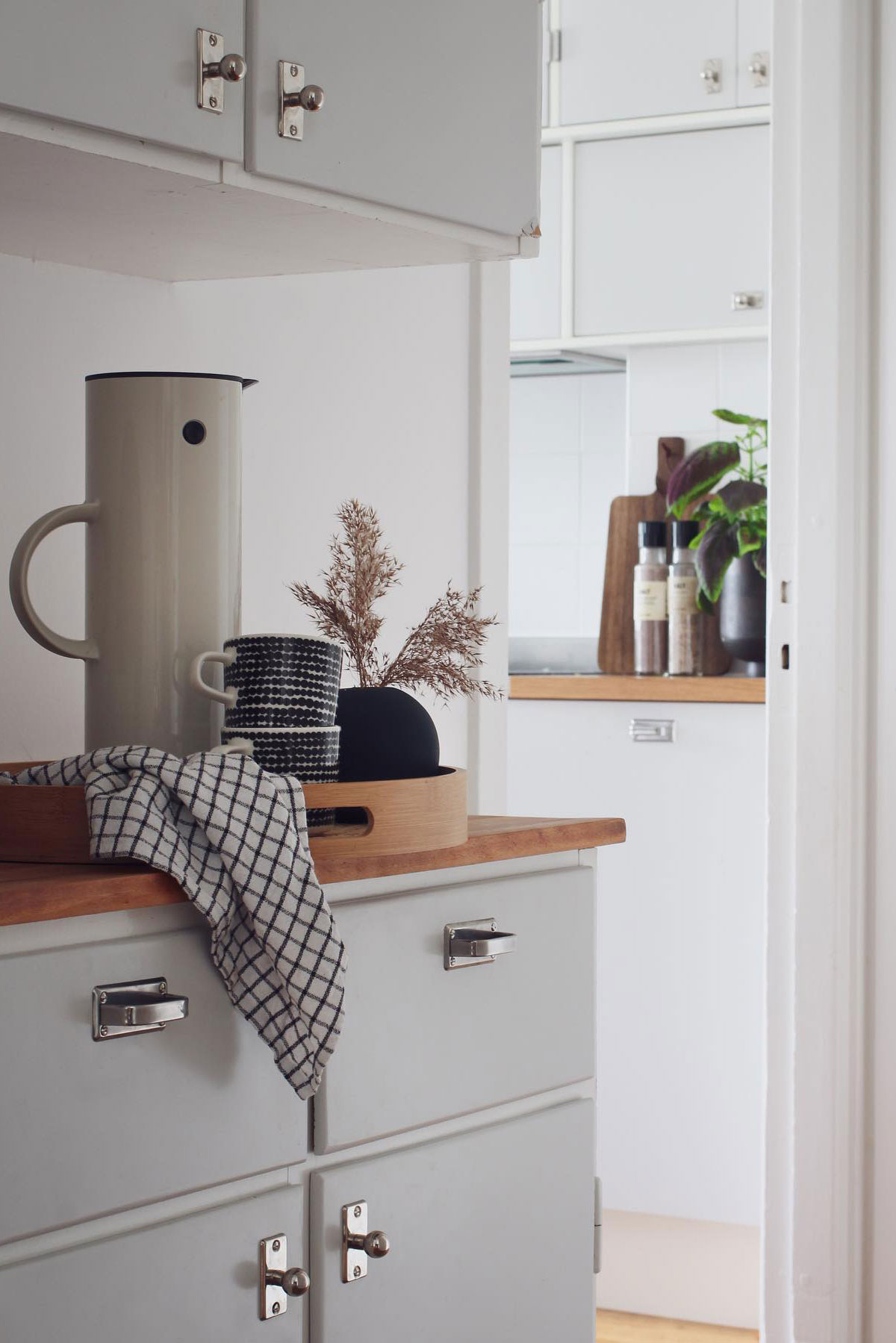 Gr&aring;tt funkisk&ouml;k med serveringsg&aring;ng i bakgrunden i vitt.