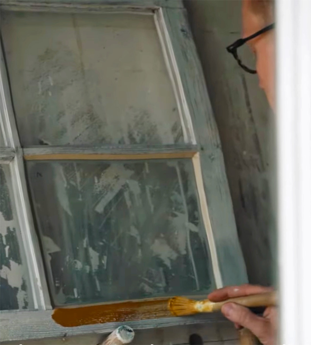 En grundm&aring;lad f&ouml;nsterb&aring;ge m&aring;las med linoljef&auml;rg i gult.