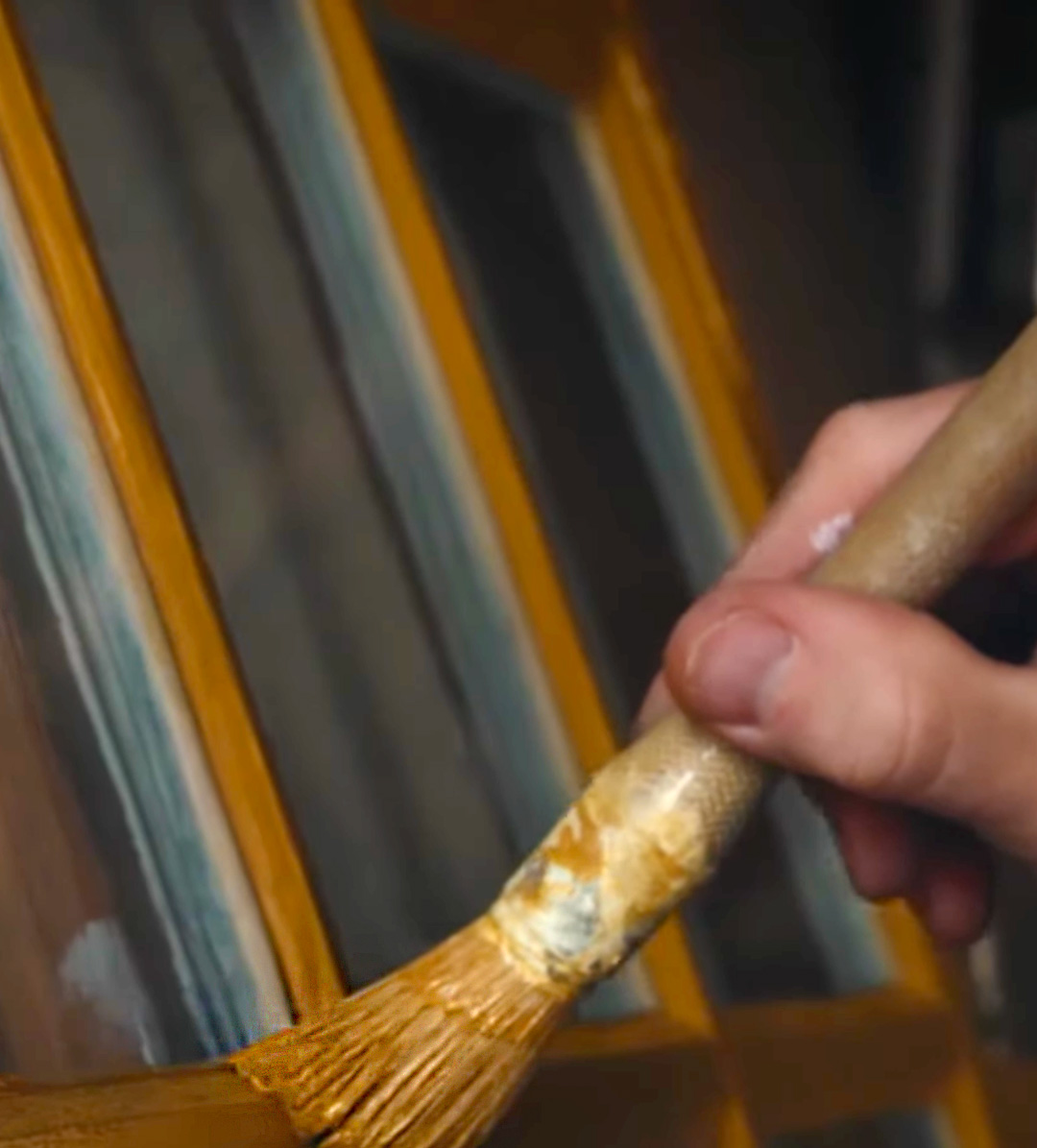 En grundm&aring;lad f&ouml;nsterb&aring;ge m&aring;las med linoljef&auml;rg i gult.