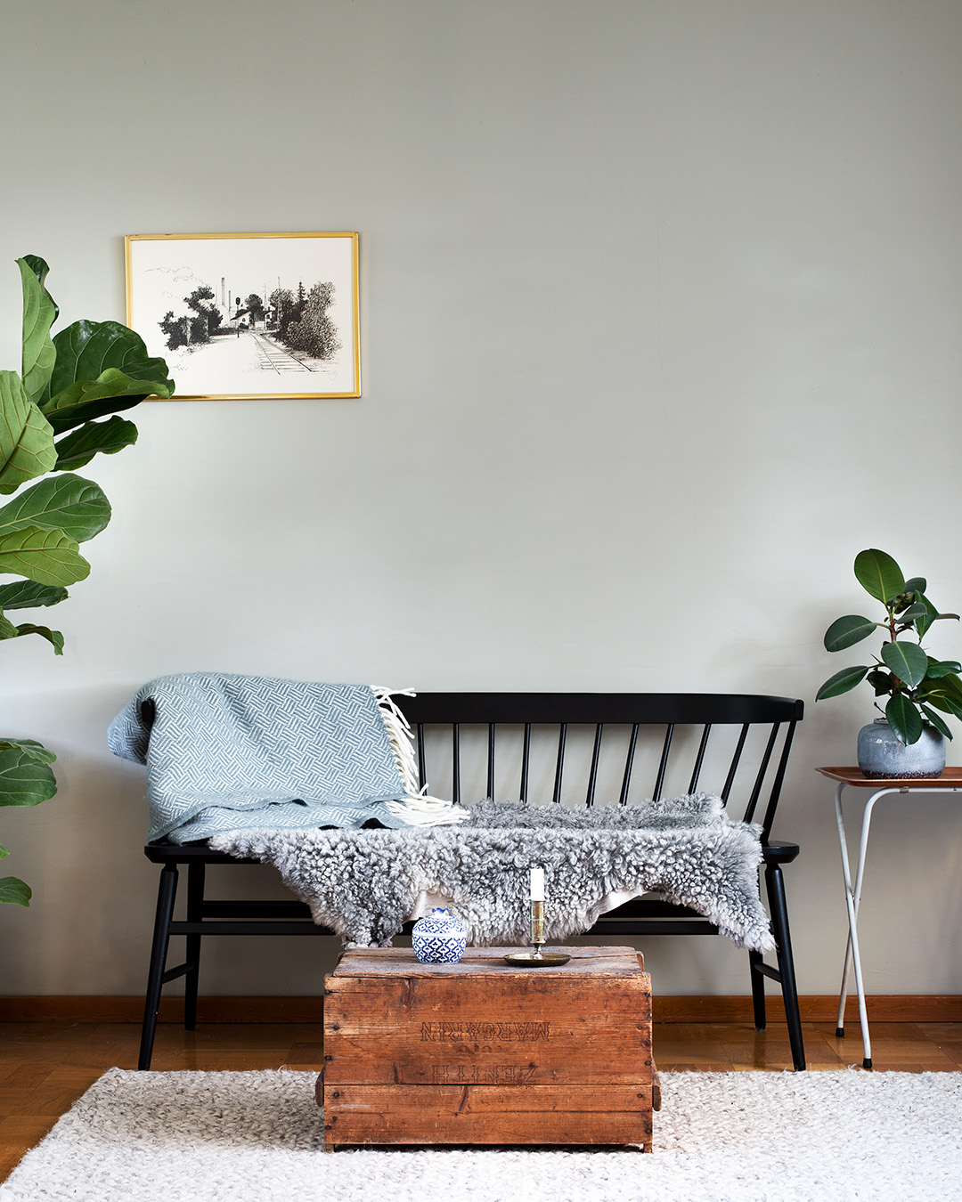 Vardagsrum med svart k&ouml;kssoffa framf&ouml;r v&auml;gg m&aring;lad med Auro v&auml;ggf&auml;rg i kul&ouml;r Gr&aring;p&auml;ron.