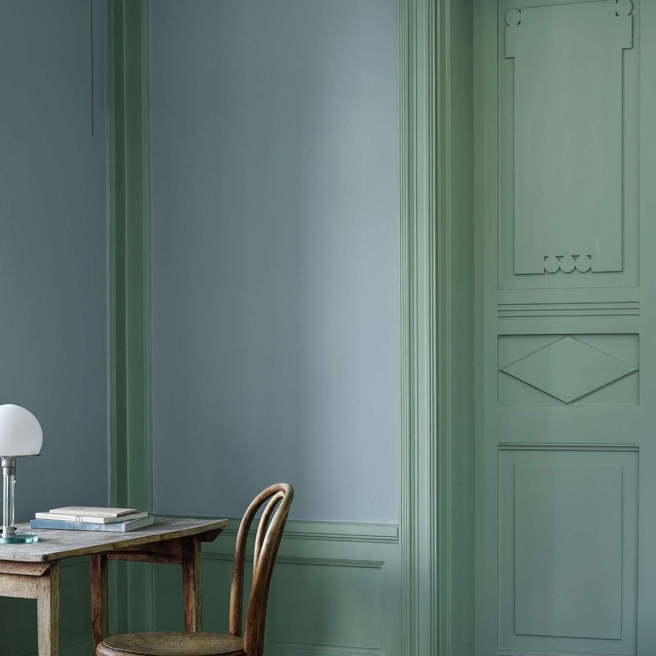 Ett rum som m&aring;lats i en harmonisk bl&aring;, kul&ouml;r Mildbl&aring; med snickerier, spegeld&ouml;rr och br&ouml;stpanel i gr&ouml;n, kul&ouml;r Tall.