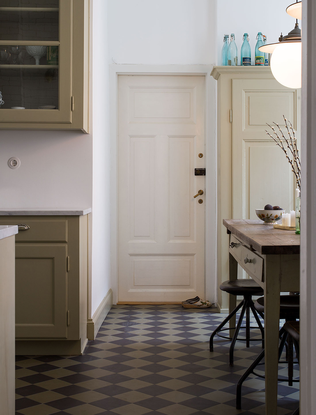 K&ouml;k med inredning m&aring;lad med linoljef&auml;rg. Klinkergolv i svart och gr&ouml;nt.