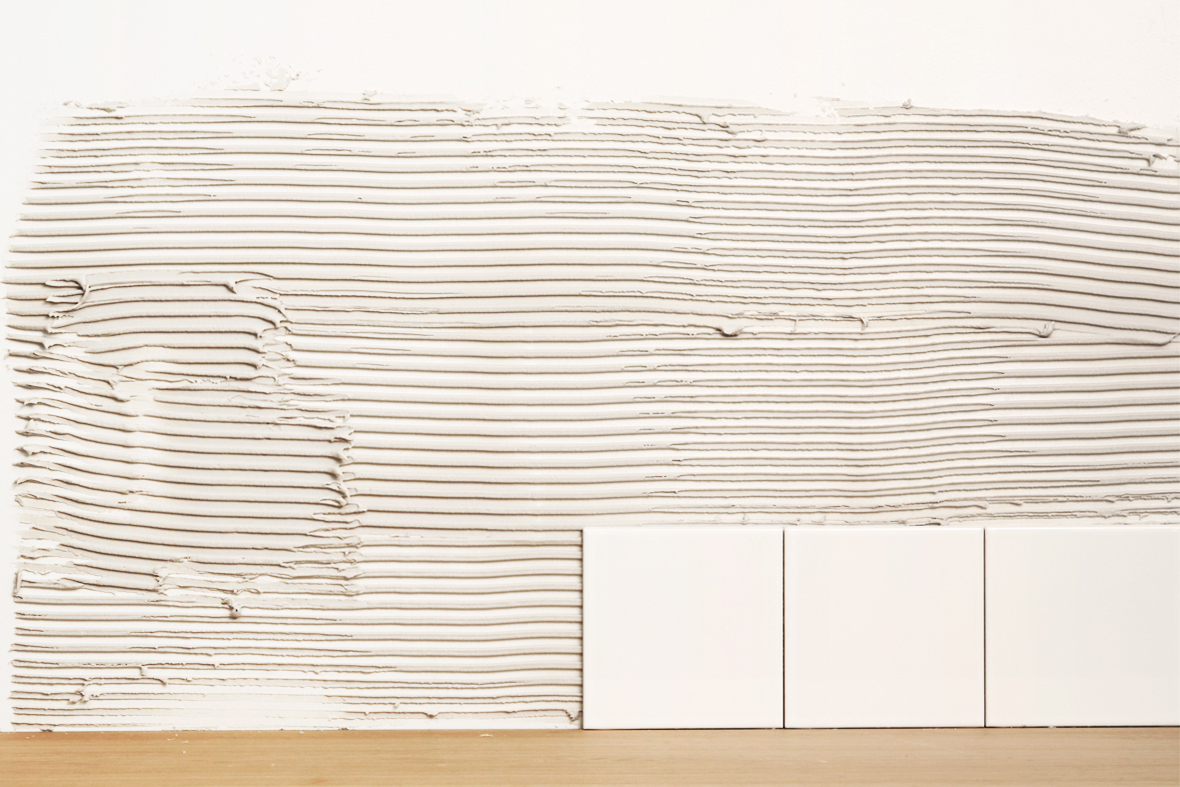 Tre plattor har satts mot v&auml;ggen i niv&aring; med b&auml;nkskivan.