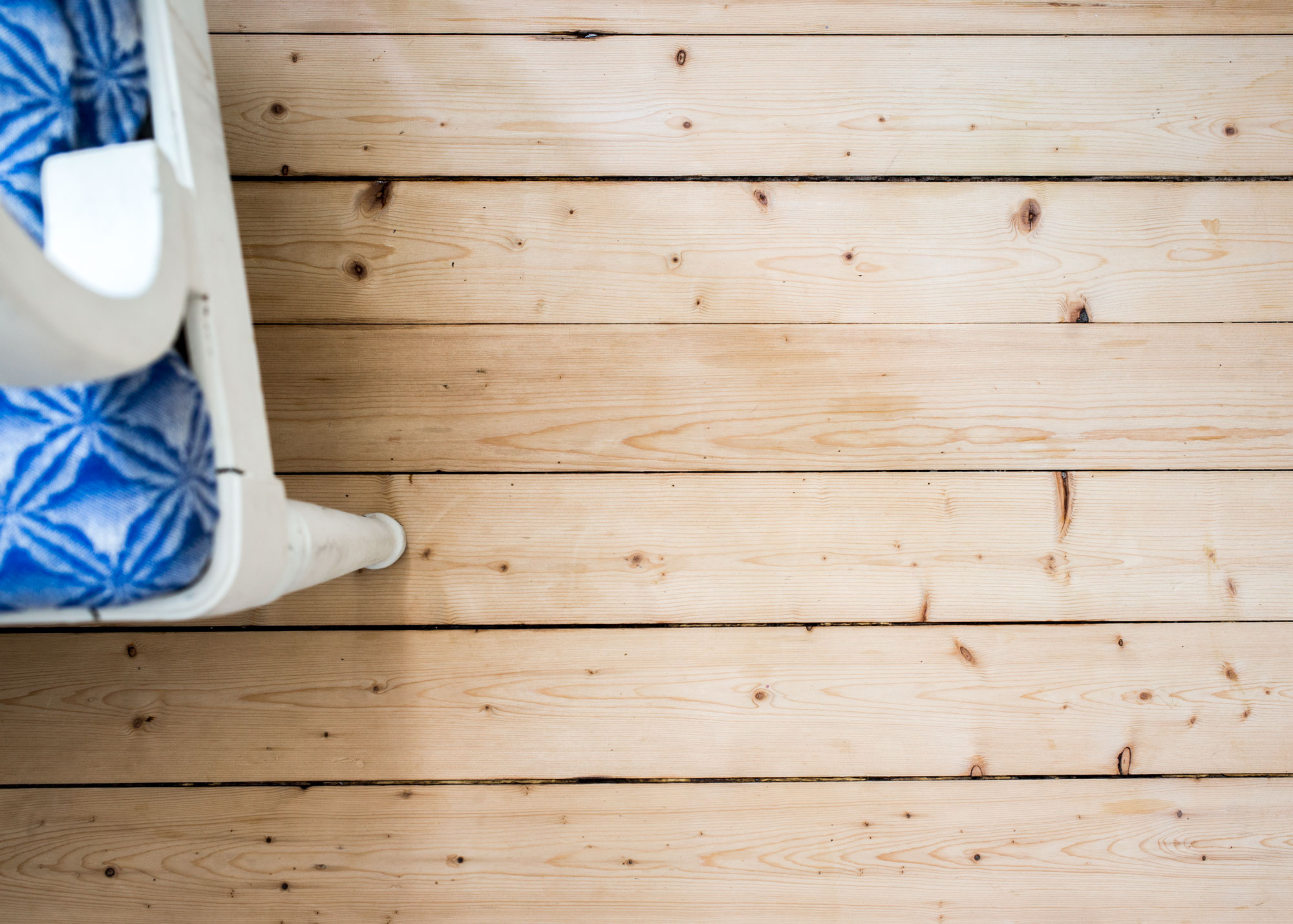 Ett nys&aring;pat k&ouml;ksgolv med en skymt av en gammaldags vitm&aring;lad k&ouml;kssoffa.