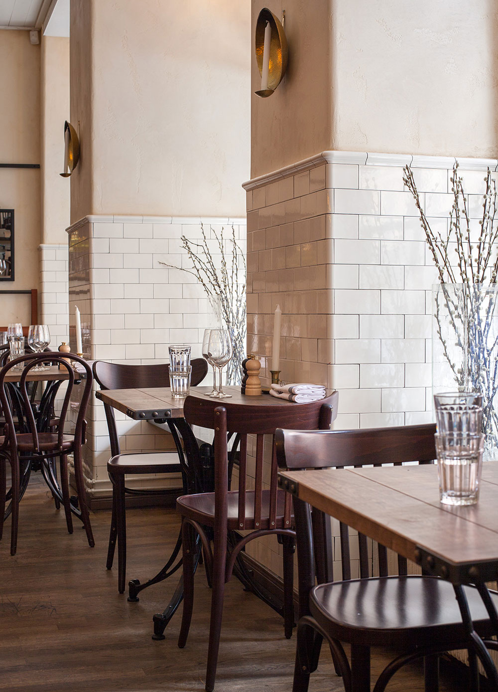 Restaurangdel med halvkaklade v&auml;ggar i cremevitt med kr&ouml;nlist.