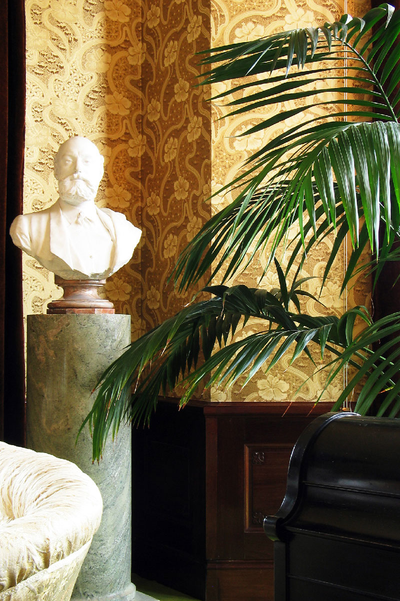 Guldtapet med en vit gipsbyst i f&ouml;rgrunden