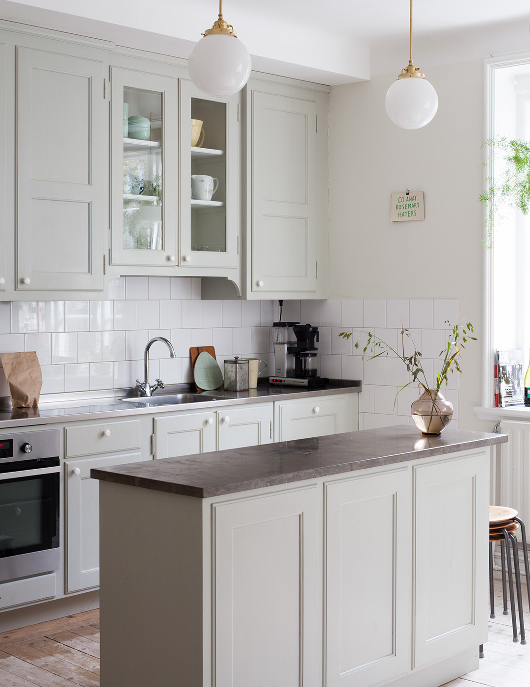 M&aring;ttbyggt k&ouml;k i tjuotalsstil med k&ouml;ks&ouml; m&aring;lat i ljust gr&aring;gr&ouml;n linoljef&auml;rg.