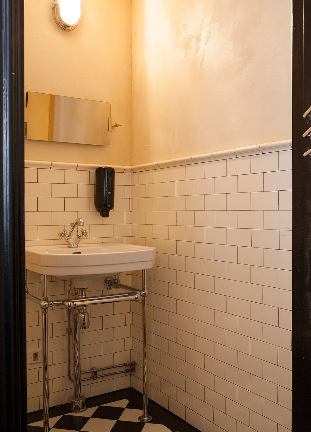 Toalett med halvkaklade v&auml;ggar i Half Tileformat och profilerat avslut.