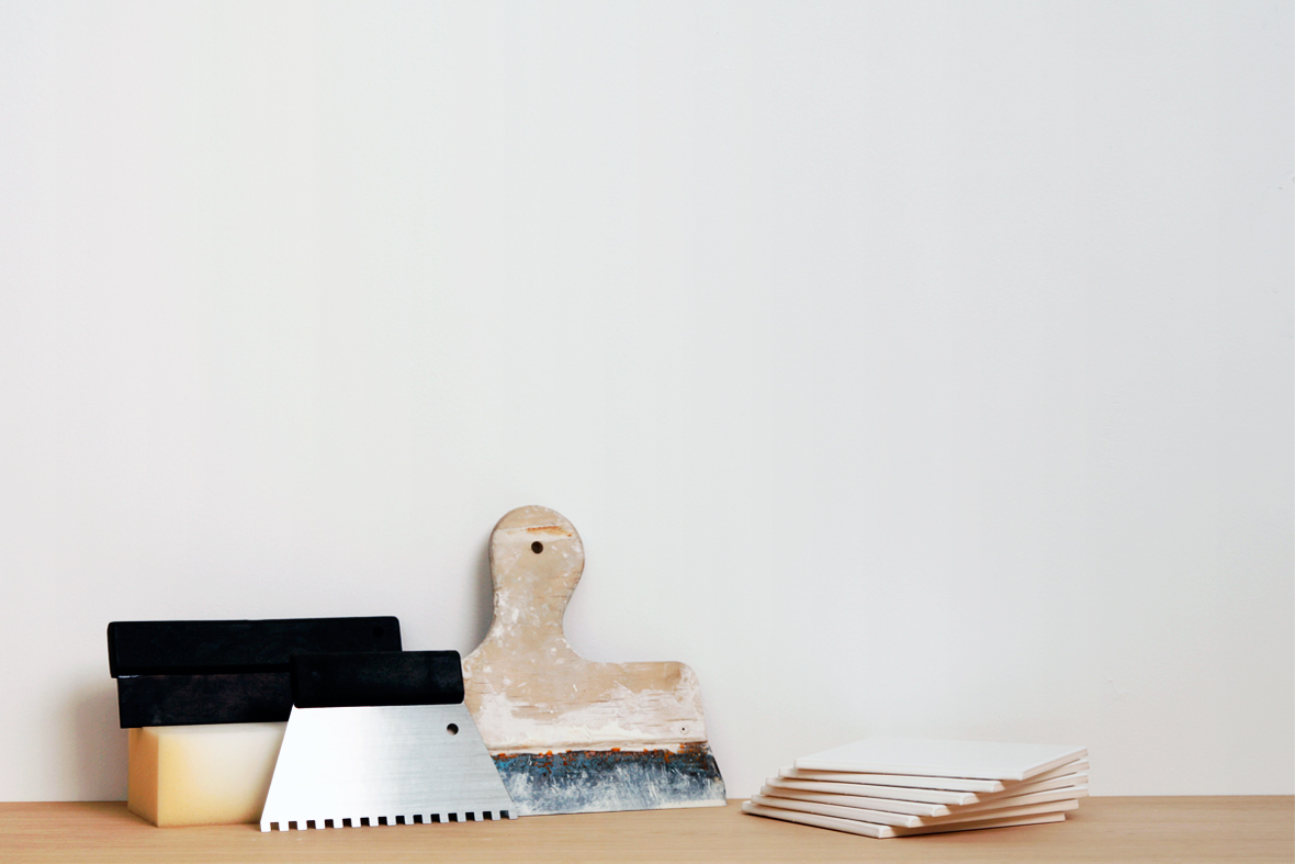 Verktyg f&ouml;r kakels&auml;ttning s&aring;som fixkam, svamp och spackel.